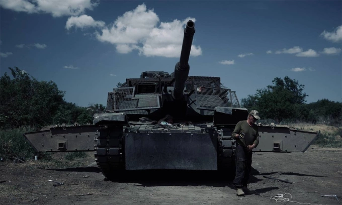 Binh sĩ Ukraine đứng trước xe tăng M1 Abrams được lắp giáp lồng và giáp phản ứng nổ tháng 7/2024. Ảnh: BQP Ukraine