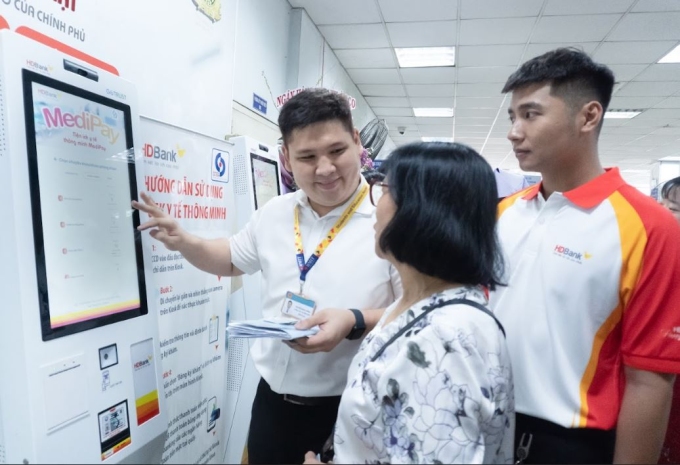 Nhân viên HDBank hướng dẫn người dân tìm hiểu Kiosk y tế thông minh. Ảnh: HDBank